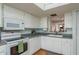 Well-lit kitchen featuring white cabinets, a skylight, and modern appliances at 11241 Dollar Lake Dr # 5, Port Richey, FL 34668