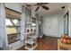 Bright sunroom with wood floors, large windows, cat tree, and storage closet at 11241 Dollar Lake Dr # 5, Port Richey, FL 34668
