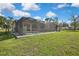 Spacious backyard featuring a screened pool enclosure and lush green lawn at 11336 Flower Ave, Weeki Wachee, FL 34613
