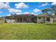 Expansive backyard featuring a screened pool enclosure and well-maintained green lawn at 11336 Flower Ave, Weeki Wachee, FL 34613
