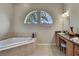 Bright bathroom featuring an angular soaking tub with tile surround and a vanity with granite countertop at 11336 Flower Ave, Weeki Wachee, FL 34613