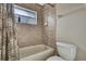 Bathroom with tiled shower/tub combination and toilet at 11336 Flower Ave, Weeki Wachee, FL 34613