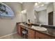 Bathroom vanity featuring double sinks, granite countertop, and decorative vase at 11336 Flower Ave, Weeki Wachee, FL 34613