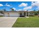 Charming single-story home with a three-car garage, arched entryway, and well-maintained lawn at 11336 Flower Ave, Weeki Wachee, FL 34613
