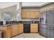 Kitchen area featuring wooden cabinets, granite countertops and stainless steel refrigerator at 11336 Flower Ave, Weeki Wachee, FL 34613