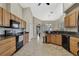 Spacious kitchen featuring wood cabinets, tile floors, granite countertops, and black appliances at 11336 Flower Ave, Weeki Wachee, FL 34613