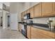 Kitchen featuring wood cabinets, granite countertops, black appliances and tile floors at 11336 Flower Ave, Weeki Wachee, FL 34613