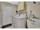 Bright laundry room with washer, dryer, and storage space at 11336 Flower Ave, Weeki Wachee, FL 34613