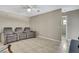 Comfortable living room with neutral walls, tile flooring, ceiling fan, and comfortable, reclining seating at 11336 Flower Ave, Weeki Wachee, FL 34613