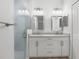 Bright bathroom with a double vanity, framed mirrors, modern lighting, and a glass enclosed shower at 12331 Fulmar Rd, Weeki Wachee, FL 34614