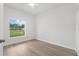 Bright bedroom featuring a ceiling fan, light wood flooring, and a large window at 12331 Fulmar Rd, Weeki Wachee, FL 34614