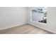 Cozy bedroom showcasing a large window, neutral walls, and modern wood-look flooring at 12331 Fulmar Rd, Weeki Wachee, FL 34614