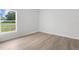 Bright bedroom featuring a large window, light wood flooring, and white trim at 12331 Fulmar Rd, Weeki Wachee, FL 34614