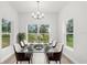 Dining room with modern chandelier, and large windows, with a table set for dinner at 12331 Fulmar Rd, Weeki Wachee, FL 34614