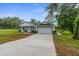 A long concrete driveway complements the charming single-Gathering home with lush landscaping at 12331 Fulmar Rd, Weeki Wachee, FL 34614