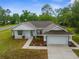 Beautifully landscaped single-story home featuring a neutral palette, and attached two-car garage at 12331 Fulmar Rd, Weeki Wachee, FL 34614