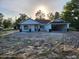 Charming single-story home featuring white exterior, dark trim, and a spacious front yard awaiting landscaping at 12331 Fulmar Rd, Weeki Wachee, FL 34614