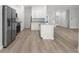 Spacious kitchen featuring modern stainless steel appliances, white cabinets, and eat-in island at 12331 Fulmar Rd, Weeki Wachee, FL 34614