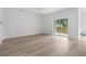 Open living room with light wood flooring, a ceiling fan, and a sliding glass door to the backyard at 12331 Fulmar Rd, Weeki Wachee, FL 34614