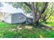 View of a serene backyard and exterior featuring a screened-in porch and mature shade tree at 12709 Castleberry Ct, Hudson, FL 34667