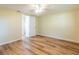 Bedroom with wood-look floors, ceiling fan and a doorway to a bathroom at 12709 Castleberry Ct, Hudson, FL 34667