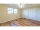 Bedroom featuring wood-look floors, closet and natural light at 12709 Castleberry Ct, Hudson, FL 34667