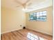 Bedroom with hardwood floors, a ceiling fan, and a large window at 12709 Castleberry Ct, Hudson, FL 34667