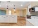 Open concept kitchen featuring an island with white countertop, modern appliances and stylish lighting at 12709 Castleberry Ct, Hudson, FL 34667