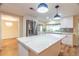 Bright kitchen features white cabinets, stainless steel appliances, island with quartz countertop, and stylish pendant lighting at 12709 Castleberry Ct, Hudson, FL 34667