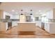 Bright kitchen features white cabinets, stainless steel appliances, island with quartz countertop, and stylish pendant lighting at 12709 Castleberry Ct, Hudson, FL 34667