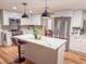 Modern kitchen features stainless steel appliances, a kitchen island with quartz countertops, and pendant lighting at 12709 Castleberry Ct, Hudson, FL 34667