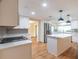 Bright kitchen features white cabinets, stainless steel appliances, island with quartz countertop, and stylish pendant lighting at 12709 Castleberry Ct, Hudson, FL 34667