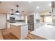 Bright kitchen features white cabinets, stainless steel appliances, island with quartz countertop, and stylish pendant lighting at 12709 Castleberry Ct, Hudson, FL 34667