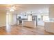 Open concept kitchen featuring an island with white countertop, modern appliances and stylish lighting at 12709 Castleberry Ct, Hudson, FL 34667
