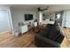 Comfortable living room with hardwood floors, a grey couch, a ceiling fan, and a modern entertainment center at 12709 Castleberry Ct, Hudson, FL 34667