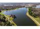 Panoramic aerial view of a large lake surrounded by green spaces, walking trails, and wooded areas at 12889 Burns Dr, Odessa, FL 33556