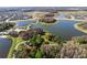 Aerial view of lakes with treed islands, surrounding community and winding roadways at 12889 Burns Dr, Odessa, FL 33556
