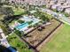 Aerial view of a community pool and park with playgrounds, lounge areas and walking trails at 12889 Burns Dr, Odessa, FL 33556