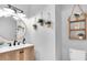 Stylish powder room featuring wood vanity, vessel sink, and unique hanging plant décor at 12889 Burns Dr, Odessa, FL 33556