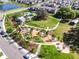 Aerial view showcasing a community park, pool, playgrounds, a lake, and residential area surrounded by nature at 12889 Burns Dr, Odessa, FL 33556