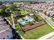 Aerial view of a community showcasing a pool, park, and neighborhood homes with lush green landscapes at 12889 Burns Dr, Odessa, FL 33556