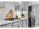 Kitchen detail showcasing a gas cooktop, quartz countertops, and stainless steel refrigerator at 12889 Burns Dr, Odessa, FL 33556