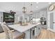 Open-concept kitchen with island seating, modern lighting, stainless appliances, and light wood floors at 12889 Burns Dr, Odessa, FL 33556