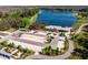 Aerial view featuring a large lake, parking area, community building, gardens, and lush green surroundings at 12889 Burns Dr, Odessa, FL 33556
