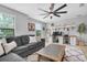 Relaxing living room features a plush sofa, patterned rug, and workspace with natural light at 12889 Burns Dr, Odessa, FL 33556