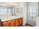Bathroom features double sinks, wood cabinets, and large mirror with decorative lighting at 13098 Hanley Dr, Spring Hill, FL 34609