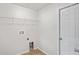 A spacious laundry room with utility connections and a wire rack for storage at 13098 Hanley Dr, Spring Hill, FL 34609