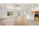 Bright living room features tile floors, neutral walls, ceiling fan, and sliding glass doors to the backyard at 13098 Hanley Dr, Spring Hill, FL 34609