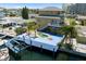 Aerial view of a waterfront home with a pool, dock, and boat lift, showcasing outdoor amenities at 13810 Celida Ave, Hudson, FL 34667