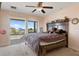 Bedroom with ceiling fan, unmade bed, and sliding glass door to deck at 13810 Celida Ave, Hudson, FL 34667